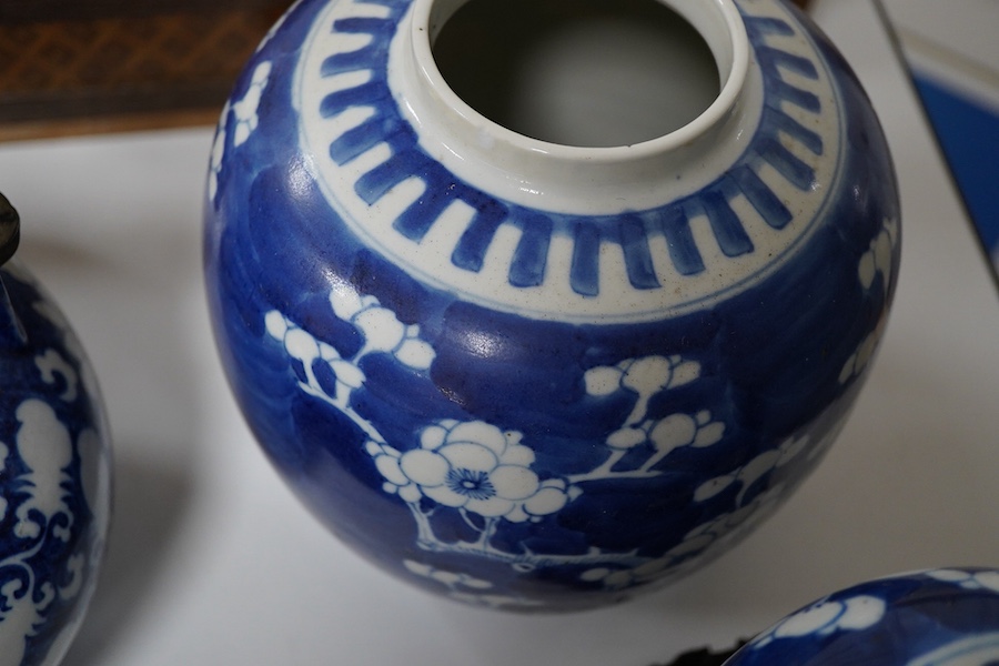 An 18th century Chinese blue and white dish, two jars (one without cover), a teapot and two carved wooden stands